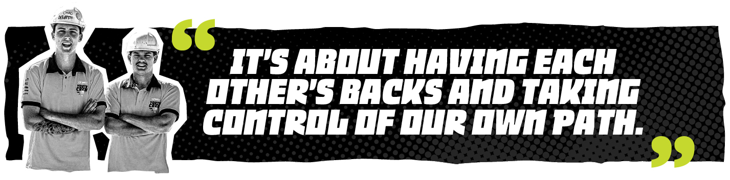 Banner with two construction workers in hard hats on a black dotted background, featuring the bold quote: 'It's about having each other's backs and taking control of our own path.'